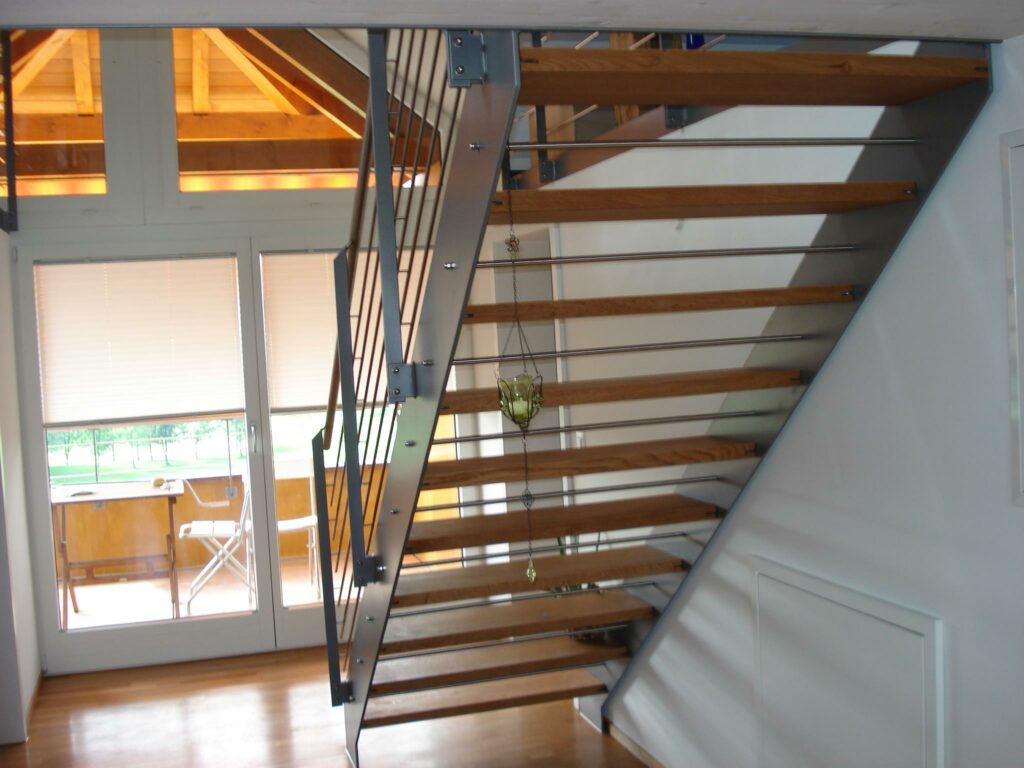 Treppe mit einbrennlackierten Wangen und Pfosten, Chromstahlrundstreben und Chromstahlhandlauf / Tritte aus Holz